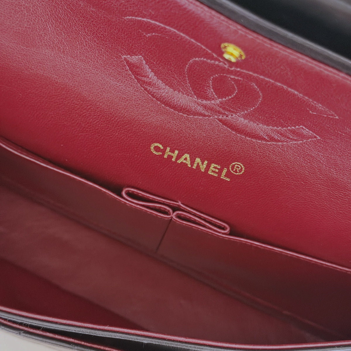 Interior da mala Chanel Classic Vintage com forro em pele vermelha, logótipo gravado e ferragens L'Héritage Du Luxe